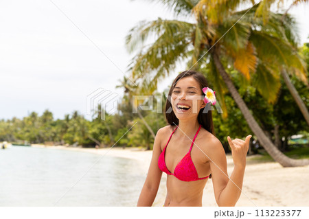 Fun laughing luxury travel beach vacation woman showing Hawaiian shaka sign traditional on Hawaii. Image is unretouched and model is without makeup. Authentic real people. Original Raw Image Fun laughing luxury travel beach vacation woman showing Hawaiian shaka sign traditional on Hawaii. Image is unretouched and model is without makeup. Authentic real people. Original Raw Image 113223377