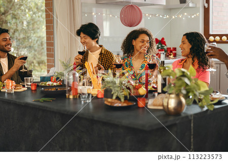 Happy young friends drinking red wine and enjoying time together at holiday party at home 113223573