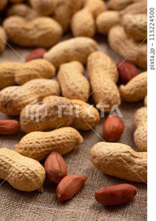 Delicious shelled peanuts on burlap. Peanut background 113224500