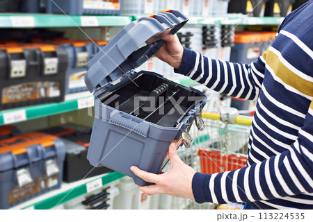 Man buyer chooses tool box in store Man buyer chooses tool box in store 113224535