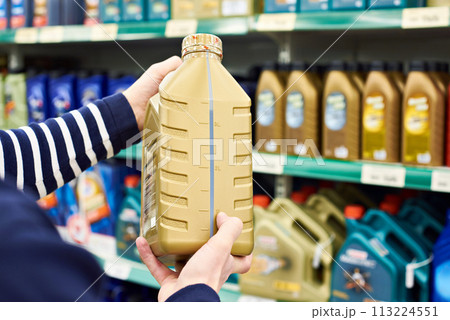 Man chooses oil for car engine in shop Man chooses oil for car engine in shop 113224551