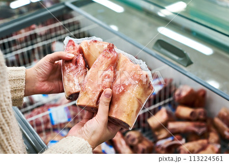 Hands with foot and ham hock meat packages at grocery Hands with foot and ham hock meat packages at grocery 113224561