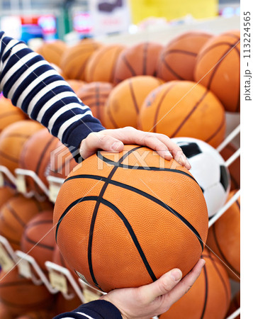 Buyer hands with basketball in sport shop Buyer hands with basketball in sport shop 113224565