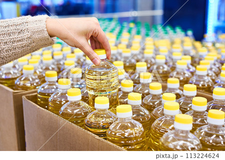 Hand with sunflower oil packaging in store Hand with sunflower oil packaging in store 113224624