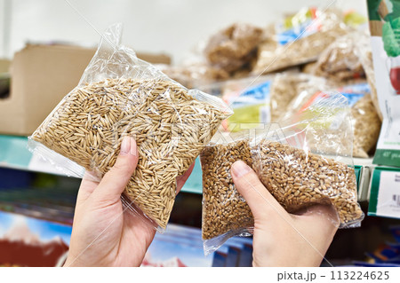 Hands with oat seeds for food in store Hands with oat seeds for food in store 113224625