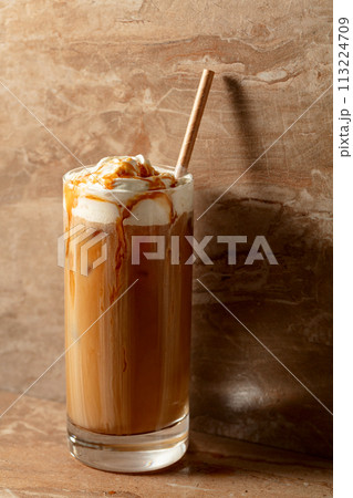 Iced caramel latte topped with whipped cream and caramel sauce. Iced caramel latte topped with whipped cream and caramel sauce. 113224709