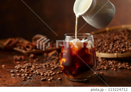 Iced coffee with cream on a brown table. 113224712