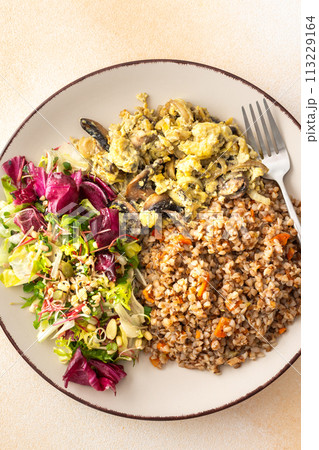 Buckwheat porridge with mixed salad and fried mushrooms with eggs 113229164