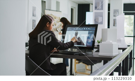 Architect reviewing residential area building plans on pc, working with interactive screen to design and outline property elements. Technician preparing for project in startup coworking space. 113229310