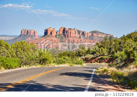Sedona Red Rock Formations with Winding Road and Greenery 113229819