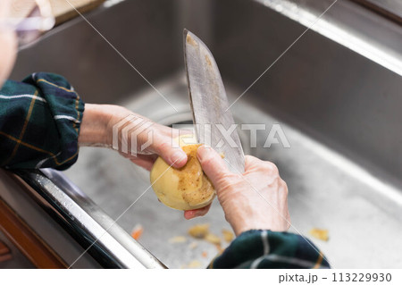 皮むき機でじゃがいもの皮むき 113229930