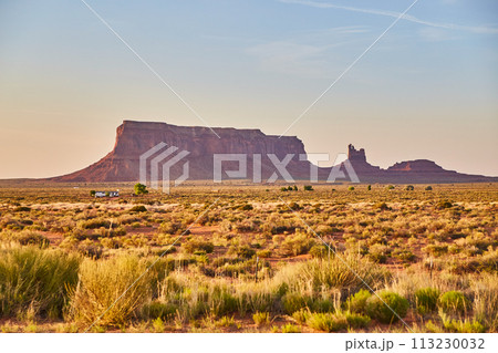 Golden Hour in Monument Valley with Desert Road and Vegetation 113230032