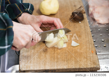 キッチンで玉ねぎを切るシニア女性 113230306