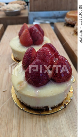 Gourmet Strawberry Cheesecake on Wooden Surface, Eye-Level View 113230389
