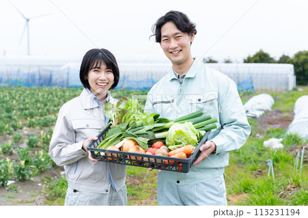 農作物を持つ農家の若い男女 113231194