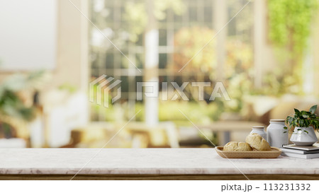 A space on a white marble table with a blurred background of a bright living room with green garden. 113231332