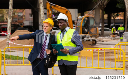 Foreman and engineer check correctness of the pipeline repair on street 113231720