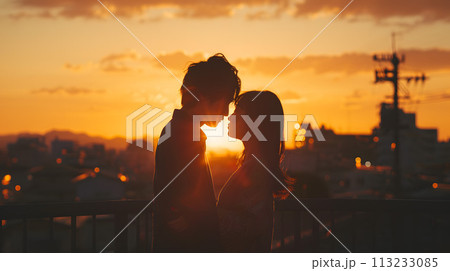 夕焼けを背に寄り添うロマンチックな日本人カップル 113233085
