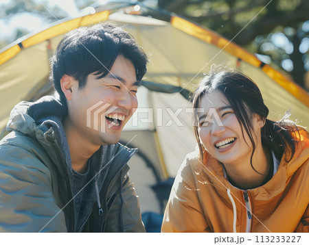 自然の中でキャンプを満喫する笑顔あふれる若い日本人カップル 自然の中でキャンプを満喫する笑顔あふれる若い日本人カップル 113233227