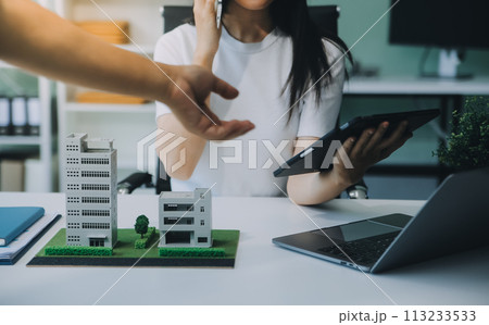 Real estate broker agent presenting and consult to customer to decision making sign insurance form agreement, buy and sell home model, concerning mortgage loan offer for and house insurance 113233533