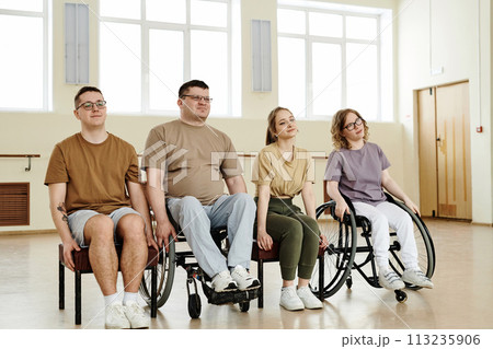Group of four diverse men and women practicing dance with wheelchairs in studio, long shot 113235906