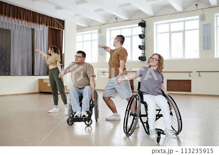 Modern wheelchair dance team having rehearsal in spacious studio, long shot, copy space Modern wheelchair dance team having rehearsal in spacious studio, long shot, copy space 113235915