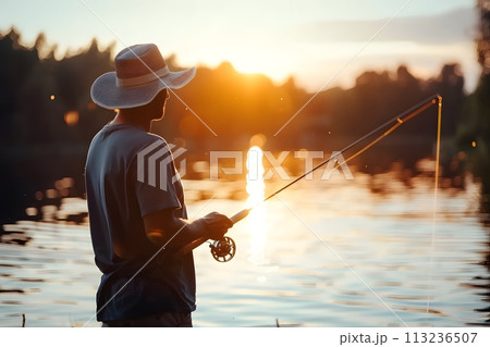 Illustration of a man is fishing by the water's edge with a thin mist floating above the water showing the cool air under the warm and beautiful morning sun. It's a very nice and private atmosphere. 113236507