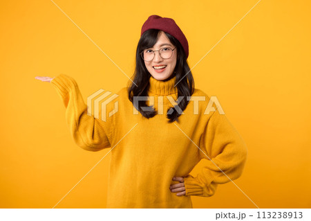 Happy female painting, 30s Asian beautiful young woman artist holding hip and pointing palm hand to free copy space, studio shot isolated on yellow background, Paintings and art advertising concept. Happy female painting, 30s Asian beautiful young woman artist holding hip and pointing palm hand to free copy space, studio shot isolated on yellow background, Paintings and art advertising concept. 113238913