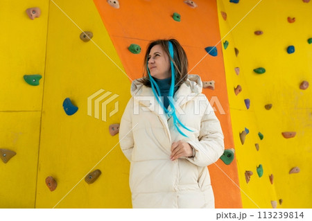 Woman Standing in Front of Climbing Wall Woman Standing in Front of Climbing Wall 113239814