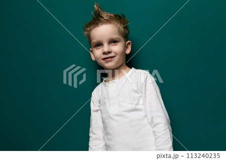 Young Boy Standing in Front of Green Wall Young Boy Standing in Front of Green Wall 113240235