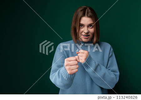 Woman in Blue Sweater Making Fist Gesture 113240826