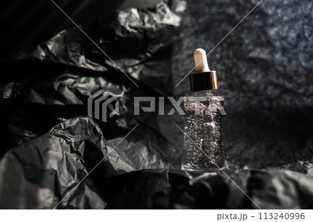 Jar with collagen, peptides, glycerin and antioxidants on a black background. The concept of helping women care for their decollete area. Jar with collagen, peptides, glycerin and antioxidants on a black background. The concept of helping women care for their decollete area. 113240996