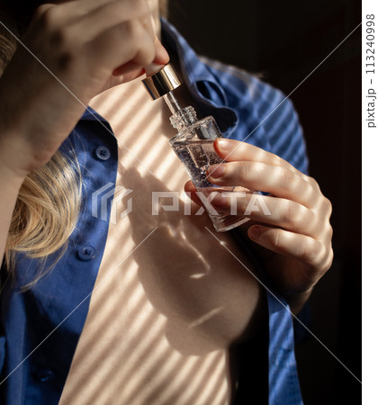 Breast serum. The girl shows her cleavage, which she will take care of with collagen, peptides, hyaluronic acid, glycerin, antioxidants, vitamins, and retinol. Prevention of breast stretch marks Breast serum. The girl shows her cleavage, which she will take care of with collagen, peptides, hyaluronic acid, glycerin, antioxidants, vitamins, and retinol. Prevention of breast stretch marks 113240998