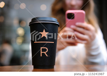 Starbucks Resort black Starbucks cup with star underline big letter R on the table in the coffee shop delicious new coffee luxury famous brand newest 113241987