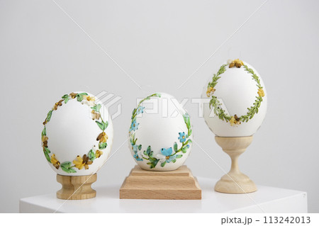 three eggs on special wooden stands on a white background lavender background postcard baner calendar empty space holiday easter eggs embroidery ribbons on eggshell krashanka 113242013