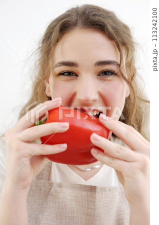 funny cheerful teen girl young woman biting red pepper healthy eating delicious food cooking salad sincerely sly look smile beautiful teeth brown hair apron kitchen close-up delicate manicure health funny cheerful teen girl young woman biting red pepper healthy eating delicious food cooking salad sincerely sly look smile beautiful teeth brown hair apron kitchen close-up delicate manicure health 113242100