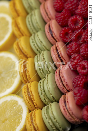 macaroons of different colors with raspberries and lemon macaroons of different colors with raspberries and lemon 113246181