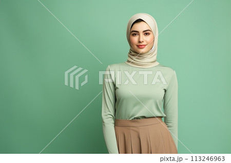 A woman wearing a green shirt and brown skirt with a white scarf on her head 113246963