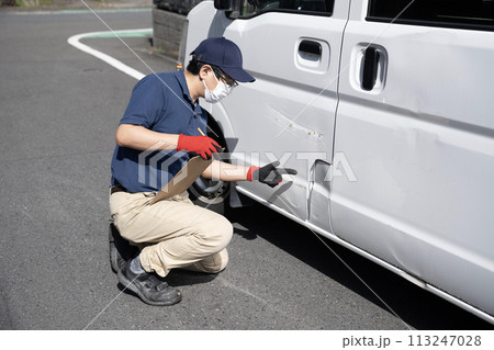 傷ついた車の修理の見積もりをする作業員 113247028