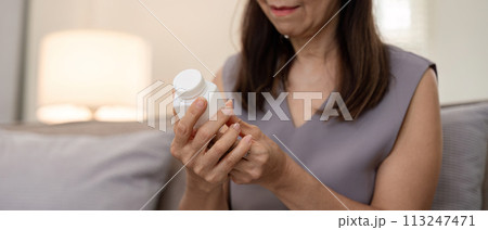 Medicine and healthcare of senior woman taking daily pill for illness, medication and sick elderly with medical drugs, vitamin or supplements in his hand 113247471