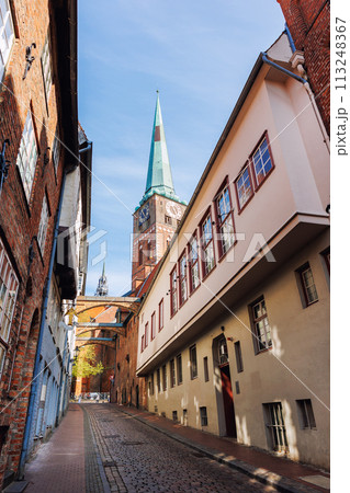 Scenic view old narrow european german Lubeck with red brick ancient houses vintage iron stained glass lamp lantern wall. Cityscape Lubeck UNESCO heritage city altstadt in Germany travel destination 113248367