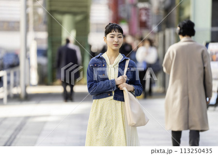 街角に立つ若い女性　カメラ目線　ポートレート 113250435