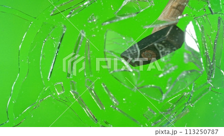 Freeze motion of glass-breaking hammer, shattering against green background Freeze motion of glass-breaking hammer, shattering against green background 113250787