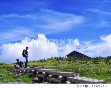 青空の湿原にてたそがれる男性 113252198