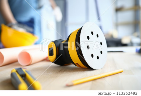 On desktop lies builder tool and sander machine On desktop lies builder tool and sander machine 113252492