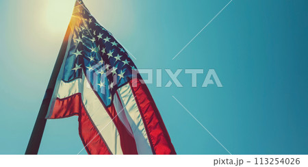 American flag waving against a clear blue sky. American flag waving against a clear blue sky. 113254026