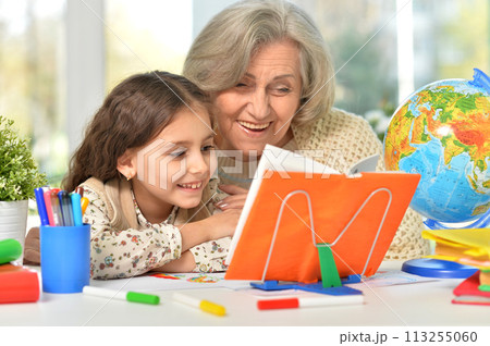 Happy Grandmother with granddaughter drawing together Happy Grandmother with granddaughter drawing together 113255060
