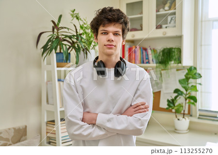 Portrait of young confident handsome guy with crossed arms, in home interior Portrait of young confident handsome guy with crossed arms, in home interior 113255270