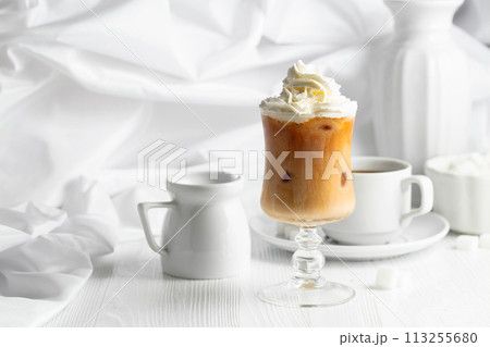 Iced caramel latte topped with whipped cream and caramel sauce. Iced caramel latte topped with whipped cream and caramel sauce. 113255680