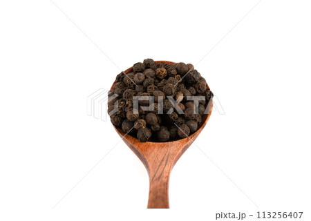 Close-up of wooden spoon with black pepper peas over white background. Close-up of wooden spoon with black pepper peas over white background. 113256407